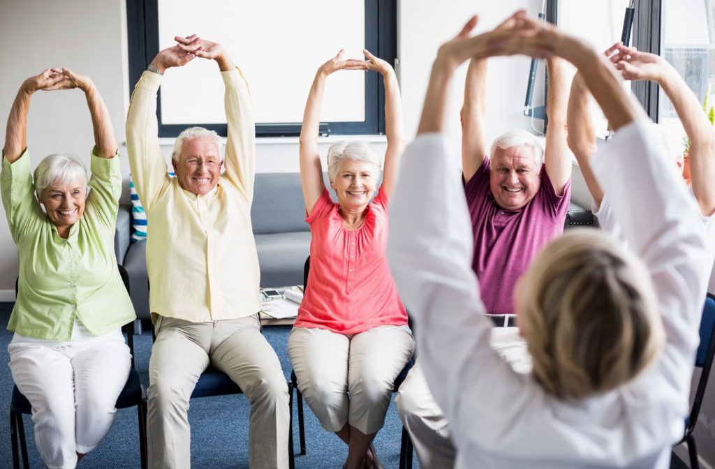 Happy seniors stretching and exercising in senior community.