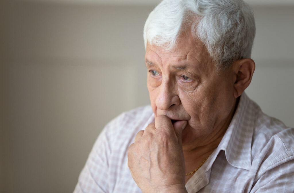 An older adult staring down thoughtfully as they try to remember something.