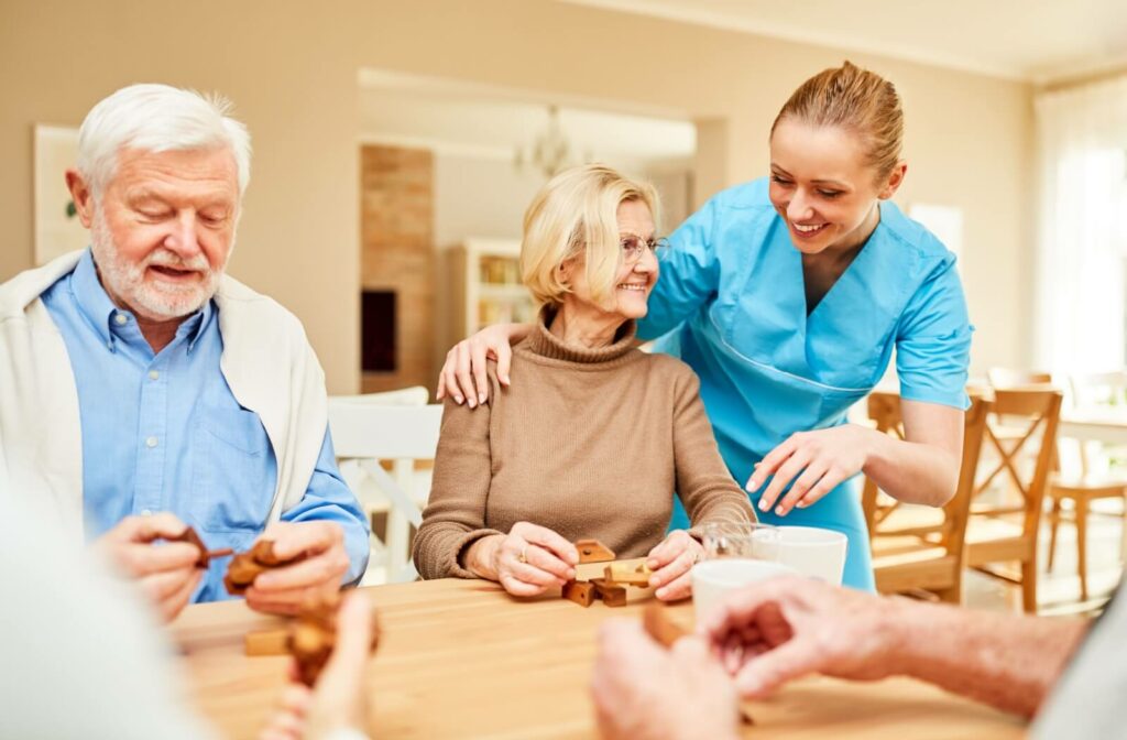 In a memory care community, a nurse helps several seniors with a block puzzle meant to help build up their cognitive skills